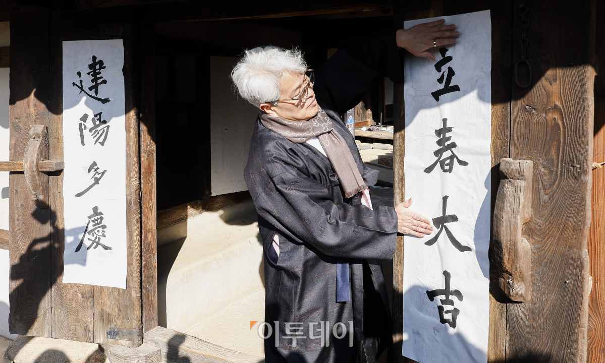 ▲절기상 봄이 시작된다는 입춘인 3일 서울 종로구 국립민속박물관 오촌댁에서 열린 입춘 세시행사에서 송현수 서예가가 '입춘대길'이라고 쓴 입춘첩을 대문에 붙이고 있다. 조현호 기자 hyunho@