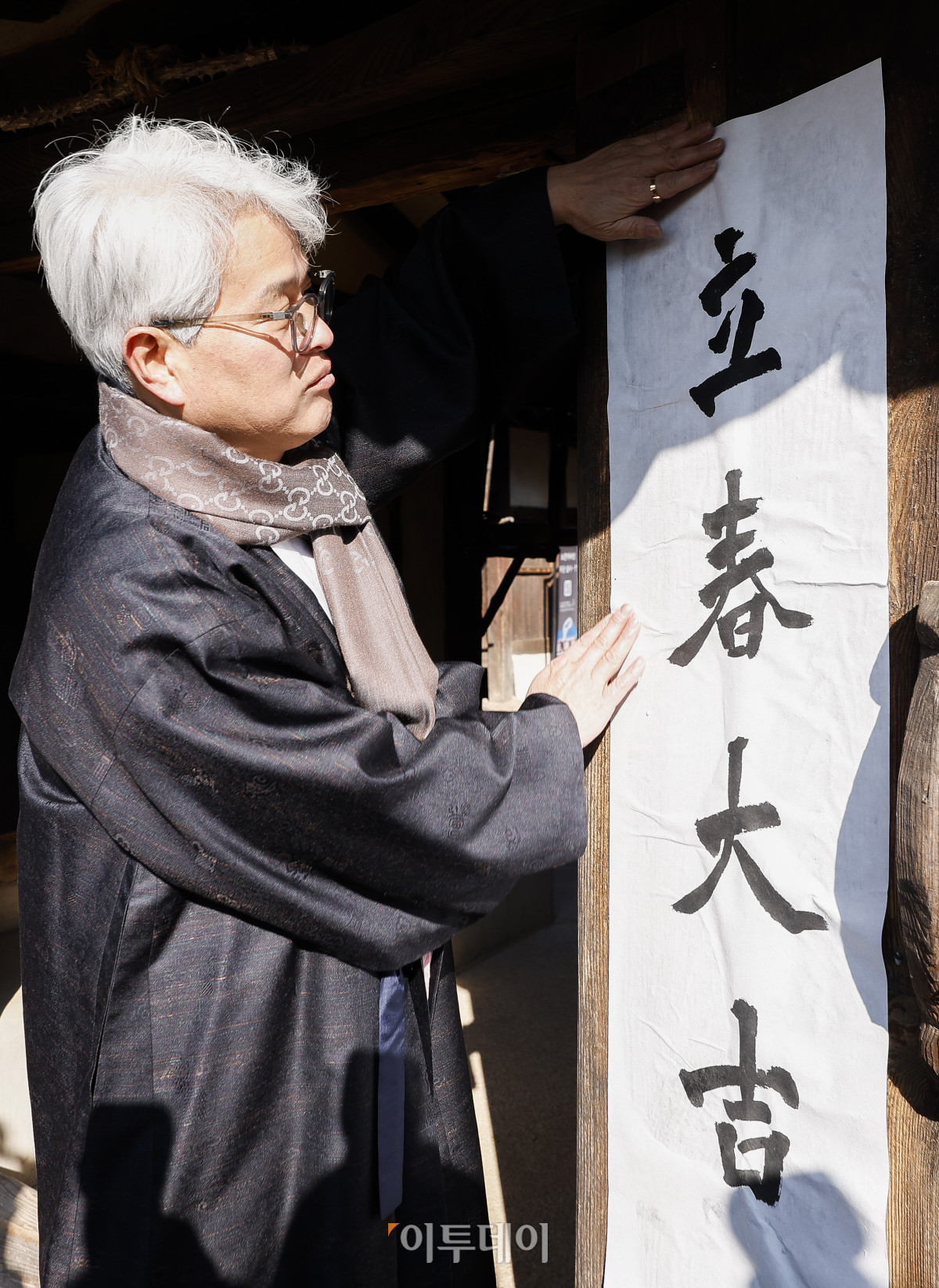 ▲절기상 봄이 시작된다는 입춘인 3일 서울 종로구 국립민속박물관 오촌댁에서 열린 입춘 세시행사에서 송현수 서예가가 '입춘대길'이라고 쓴 입춘첩을 대문에 붙이고 있다. 조현호 기자 hyunho@