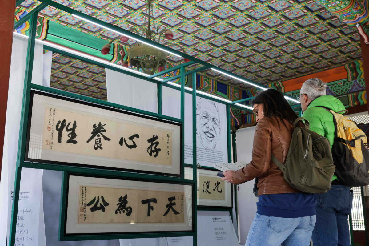 ▲스타벅스 코리아가 광복 80주년을 맞아 8일부터 덕수궁 덕홍전에서 독립유공자 친필휘호 11점을 공개하는 특별 전시회를 개최한다. 사진은 외국인 관람객들이 백범 김구 선생의 친필 글씨 '존심양성'을 보고 있는 모습. (사진제공=스타벅스코리아)