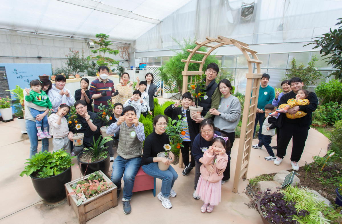▲SK케미칼은 경기 성남시에 위치한 율동생태학습원에서 봄을 맞이해 ‘봄을 심다. 마음을 잇다’ 활동을 전개했다. 봉사활동에 참여한 SK 구성원들과 가족이 기념사진을 촬영하고 있다. (사진제공=SK케미칼)