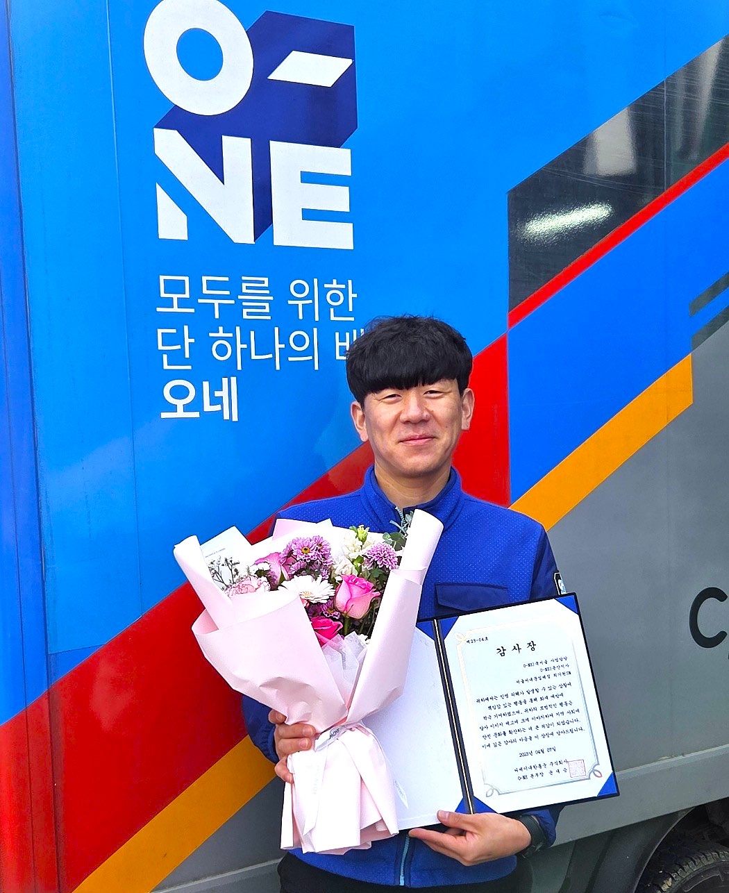 ▲CJ대한통운 택배기사 최기원 씨가 서울시 서대문구 홍제동에서 화재 현장 시민 대피 공로로 수령한 감사장을 들고 기념사진 촬영을 하고 있다. (사진=CJ대한통운)