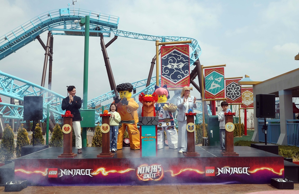 ▲피오나 이스트 우드 멀린 엔터테인먼트 CEO(맨 오른쪽), 이순규 레고랜드코리아 대표(맨 왼쪽), 어린이 앰버서더 2명(가운데)이 브릭으로 제작된 용에 불, 흙, 번개, 얼음 4개 원소를 상징하는 아이템을 장착하는 이벤트 세리머니를 진행했다. (사진제공=레고랜드 코리아)
