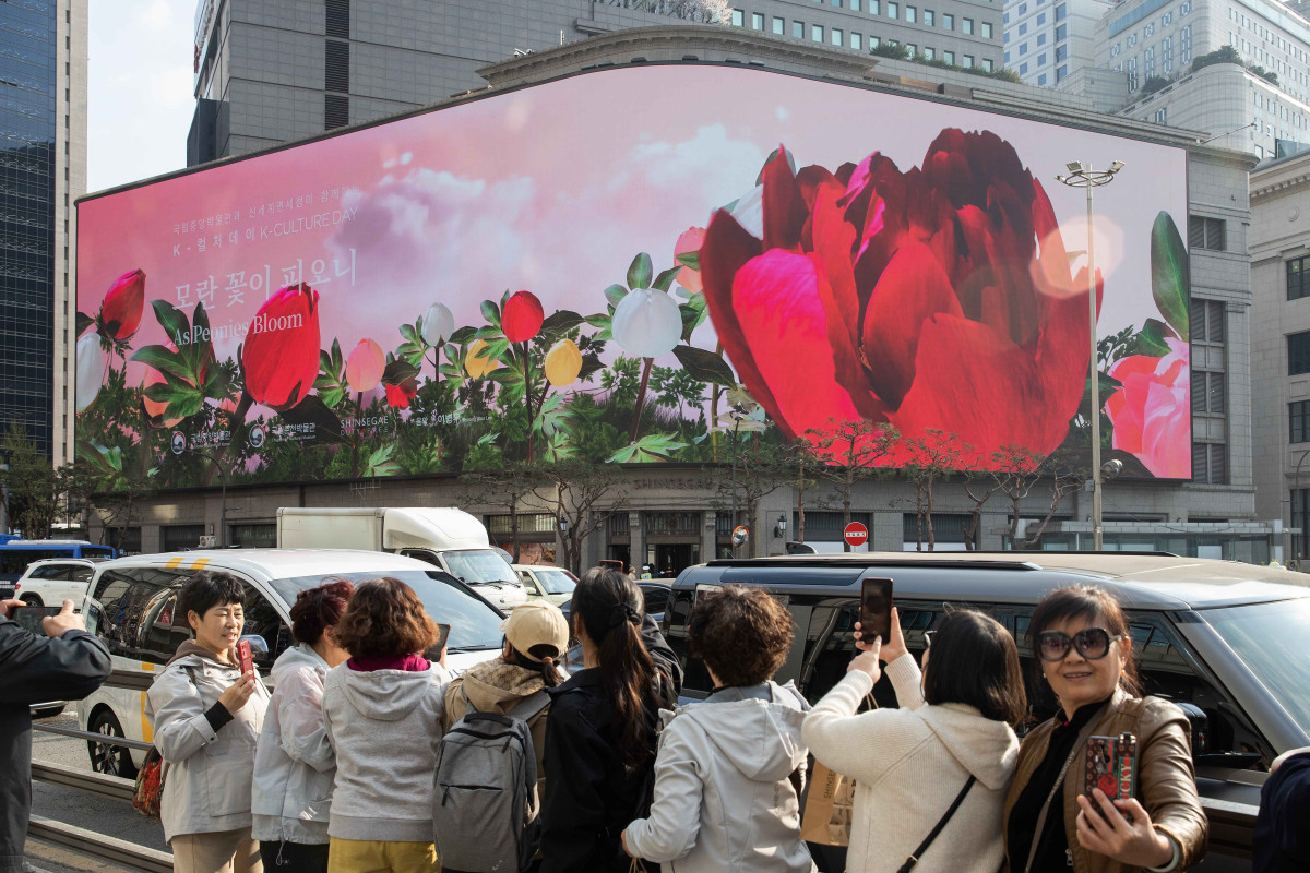▲외국인 관광객들이 서울 명동 신세계스퀘어에서 상영하는 K컬처 콘텐츠를 보며 즐거워하고 있다. (사진제공=신세계백화점)