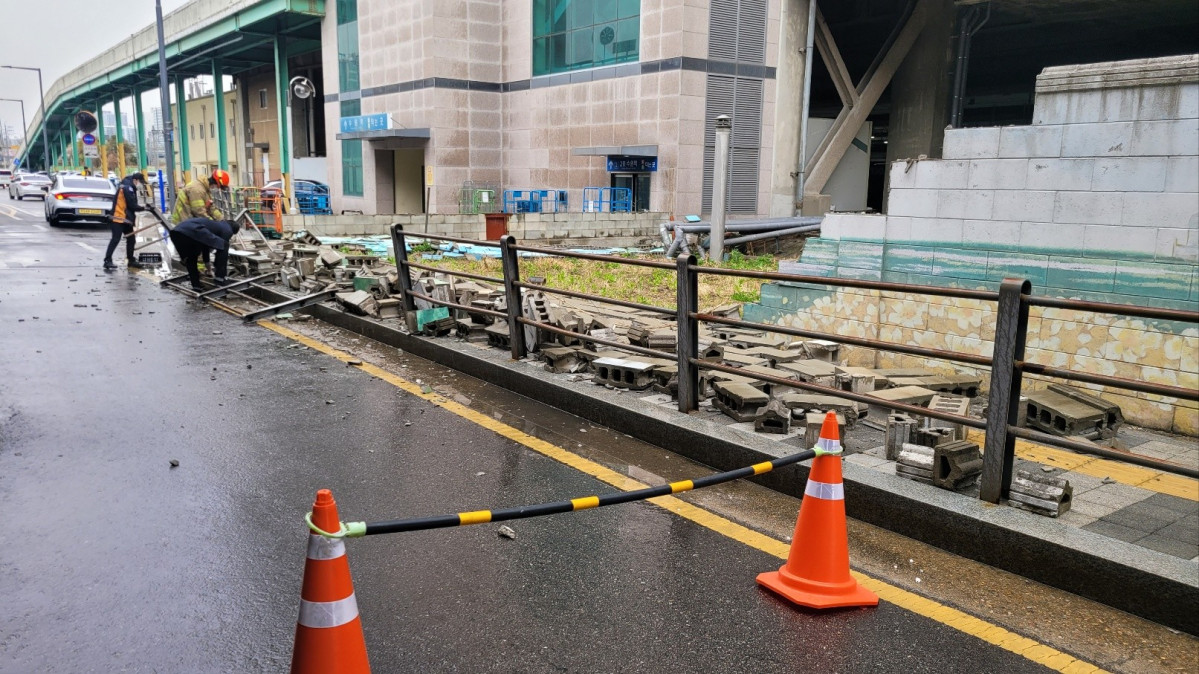 ▲13일 경기도 수원역 인근에서 관계자들이 강한 바람에 무너진 담장 주변에서 안전조치를 취하고 있다. (연합뉴스)