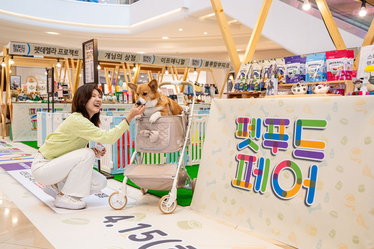 ▲스타필드 고양 ‘펫푸드 페어’에서 한 여성 고객이 강아지에게 간식을 먹이고 있다. (사진제공=신세계프라퍼티)