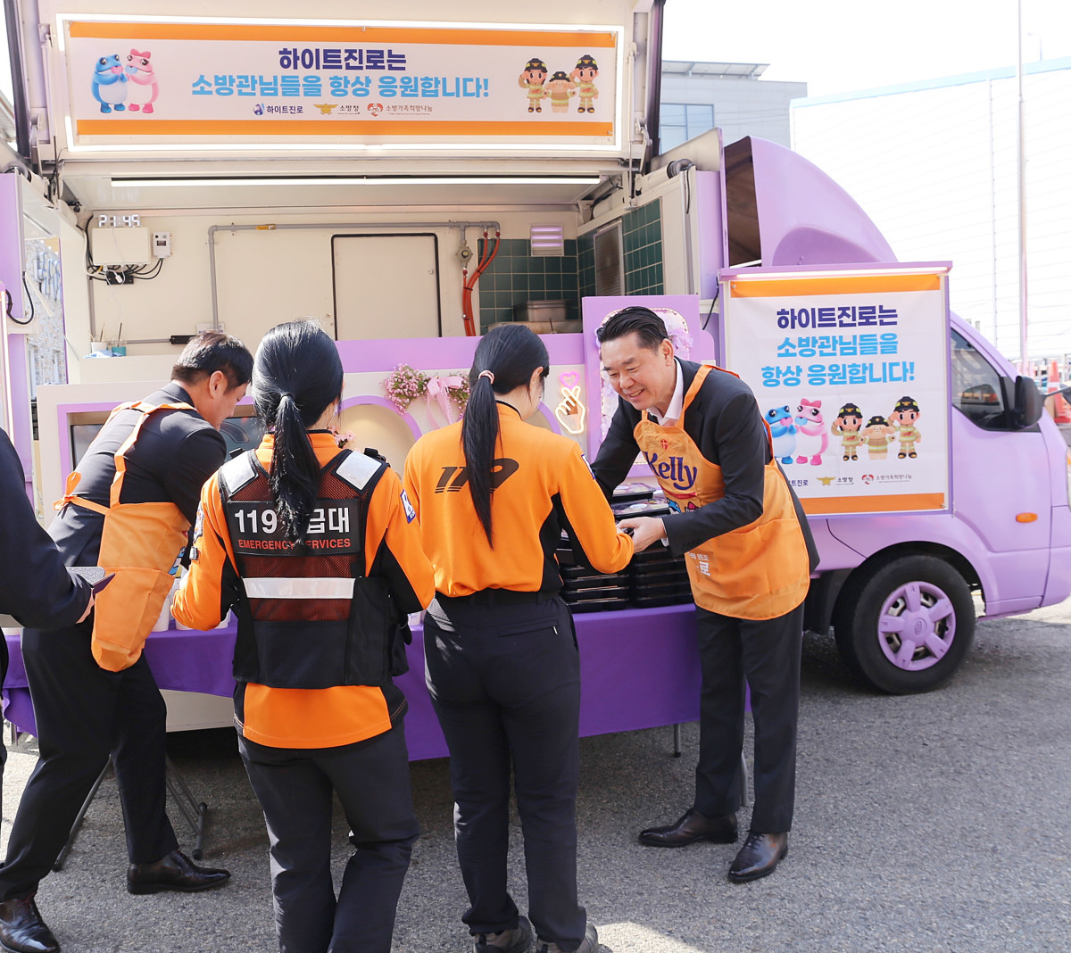 ▲ 16일 전남 목포소방서에서 김인규(오른쪽) 하이트진로 대표가 소방공무원들에게 간식을 직접 전달하고 있다. (사진제공=하이트진로)