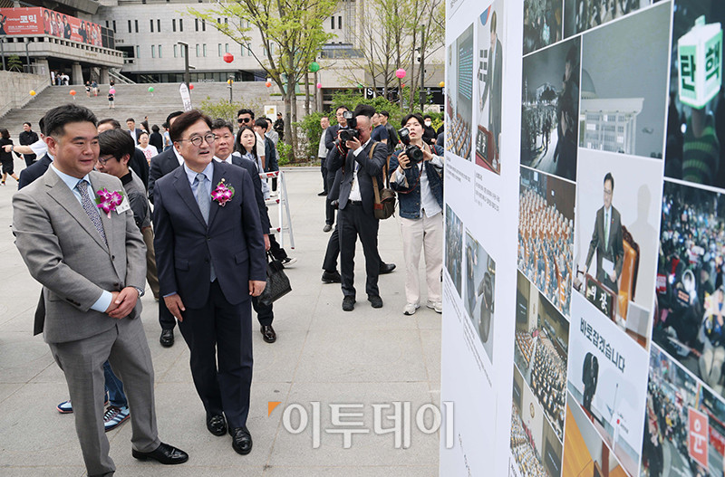 ▲이호재 한국사진기자협회장, 우원식 국회의장이 21일 서울 종로구 광화문 광장에서 열린 제61회 한국보도사진전 '순간의 포착, 진실의 기록' 개막식에서 작품을 관람하고 있다. 사진공동취재단
