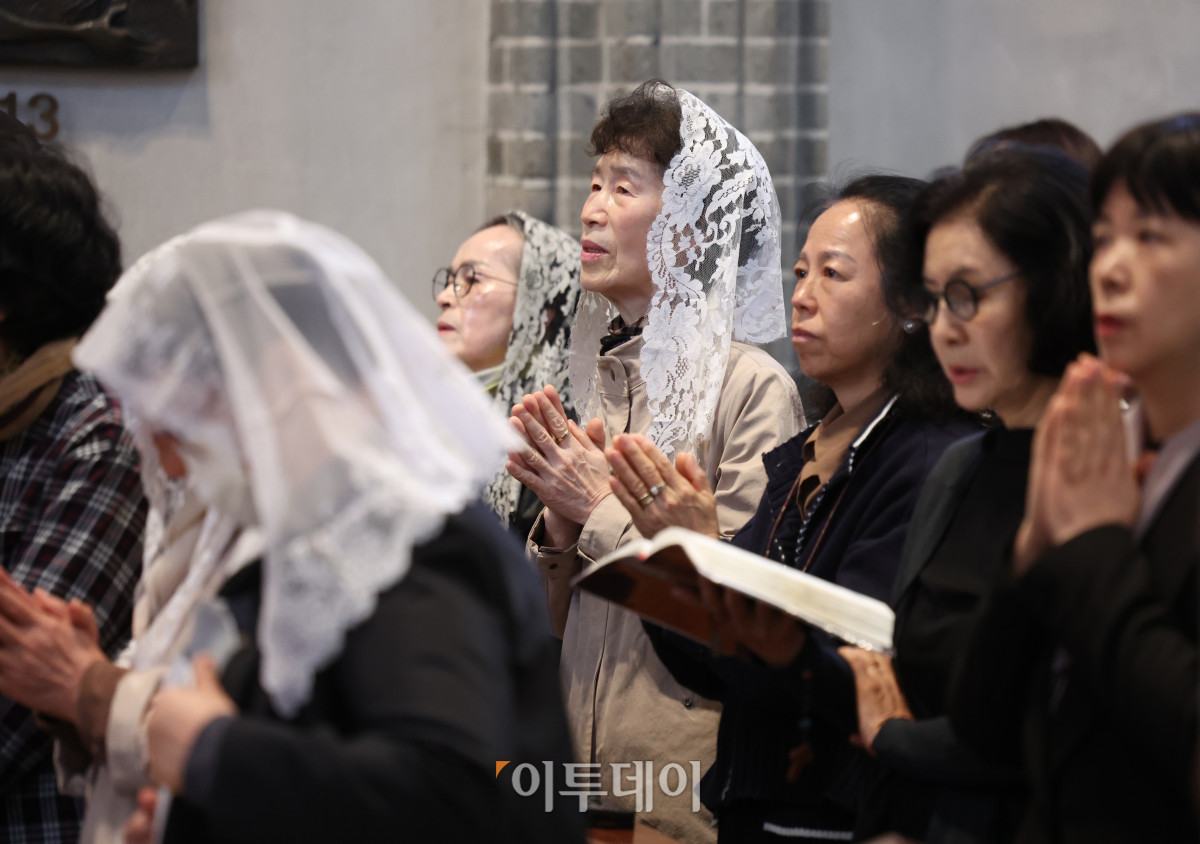 ▲24일 오전 서울 중구 명동대성당에서 거행된 프란치스코 교황 추모 미사에서 참석자들이 기도를 하고 있다. 사진공동취재단