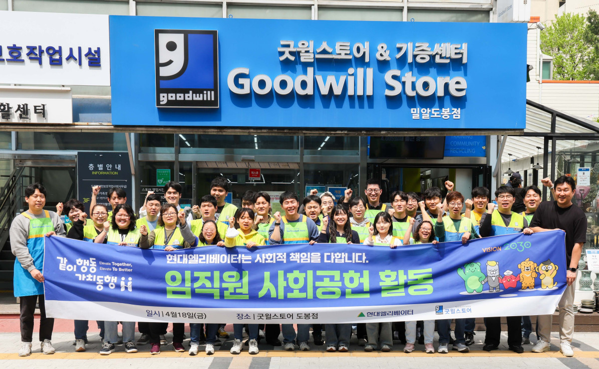 ▲현대엘리베이터 임직원들과 굿윌스토어 소속 장애인 직원들이 서울 도봉구 굿윌스토어 도봉점 앞에서 기념사진을 촬영하고 있다. (현대엘리베이터)