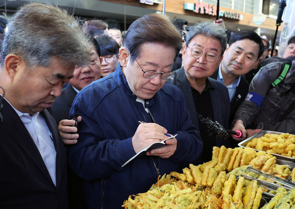 ▲민심을 청취하는 '경청 투어'에 나선 이재명 더불어민주당 대선후보가 2일 오전 강원도 철원군 동송전통시장을 찾아 청년상인과 대화하며 메모하고 있다. (사진=뉴시스)