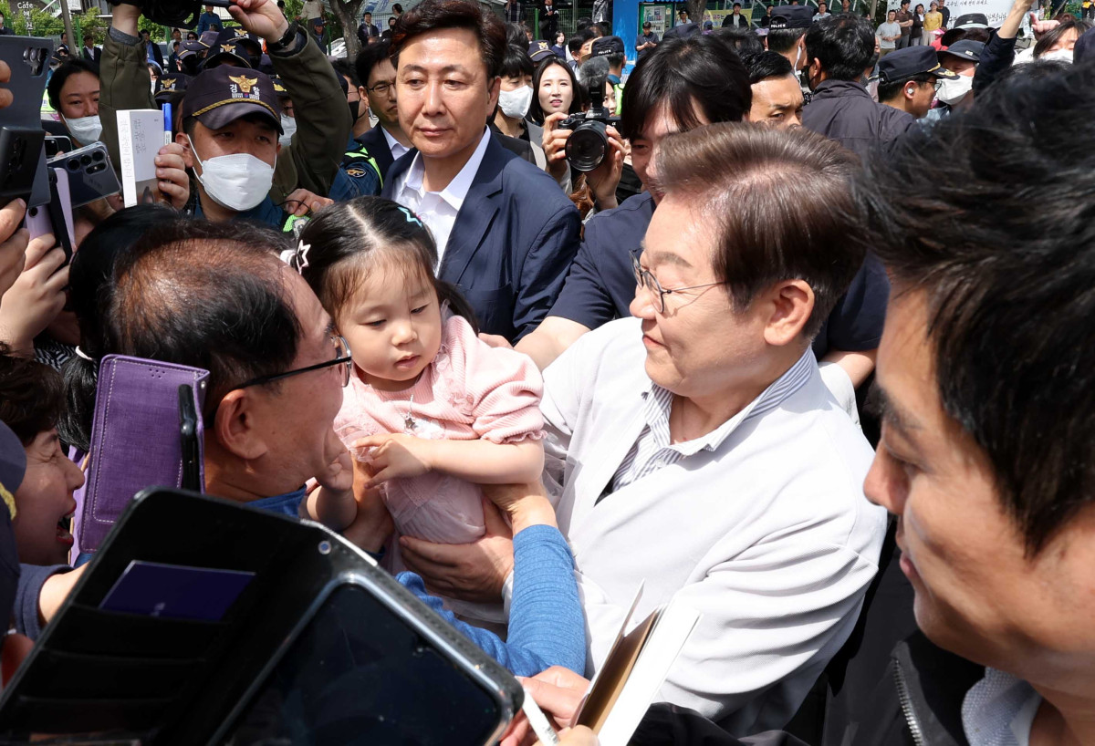 ▲ 민심을 청취하는 '경청 투어'에 나선 이재명 더불어민주당 대선후보가 7일 전북 전주시 완산구 풍남문 인근에서 어린이를 안아주고 있다. (뉴시스)