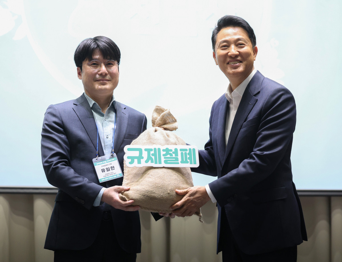 ▲오세훈 서울시장이 7일 서울 중구 서울시청에서 열린 규제철폐 100일 성과보고회에서 규제철폐 시민제안을 전달받고 있다. 뉴시스