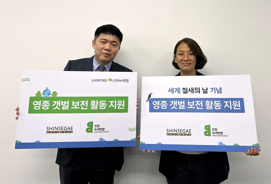 ▲서영국 신세계면세점 인천공항점장(왼쪽)과 신정은 인천녹색연합 사무처장(오른쪽)이 영종도 갯벌 보전 활동 지원금 전달식에서 기념 촬영을 하고 있다. (사진제공=신세계면세점)