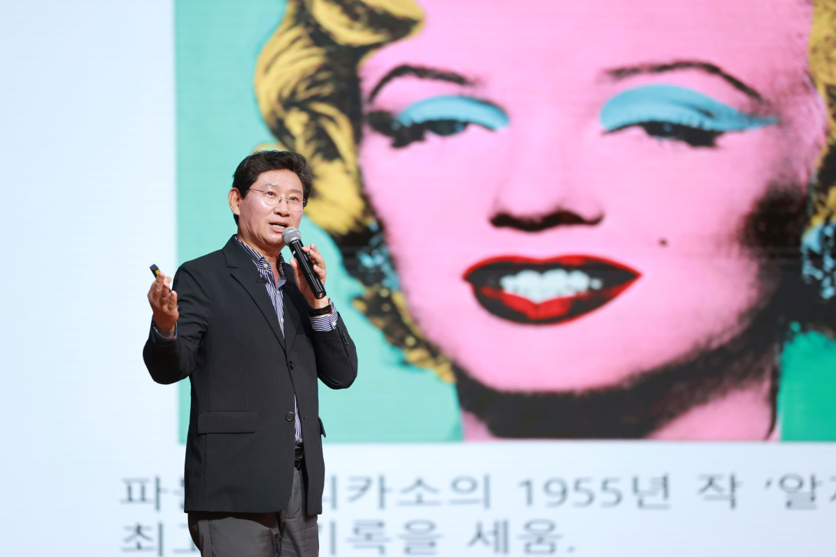 ▲이상일 용인특례시장이 7일 서울 서초문화예술회관 아트홀에서 '차이나는 아카데미' 기획 강연 중 마이크를 들고 팝 아트 스타일의 작품 앞에서 예술 작품에 대해 설명하고 있다. (용인특례시)