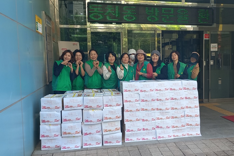 ▲용인 기흥동 주민자치위원회가 초록색 조끼를 입고 '사랑의 밑반찬' 상자를 준비하며 봉사활동을 하고 있다. (용인특례시)