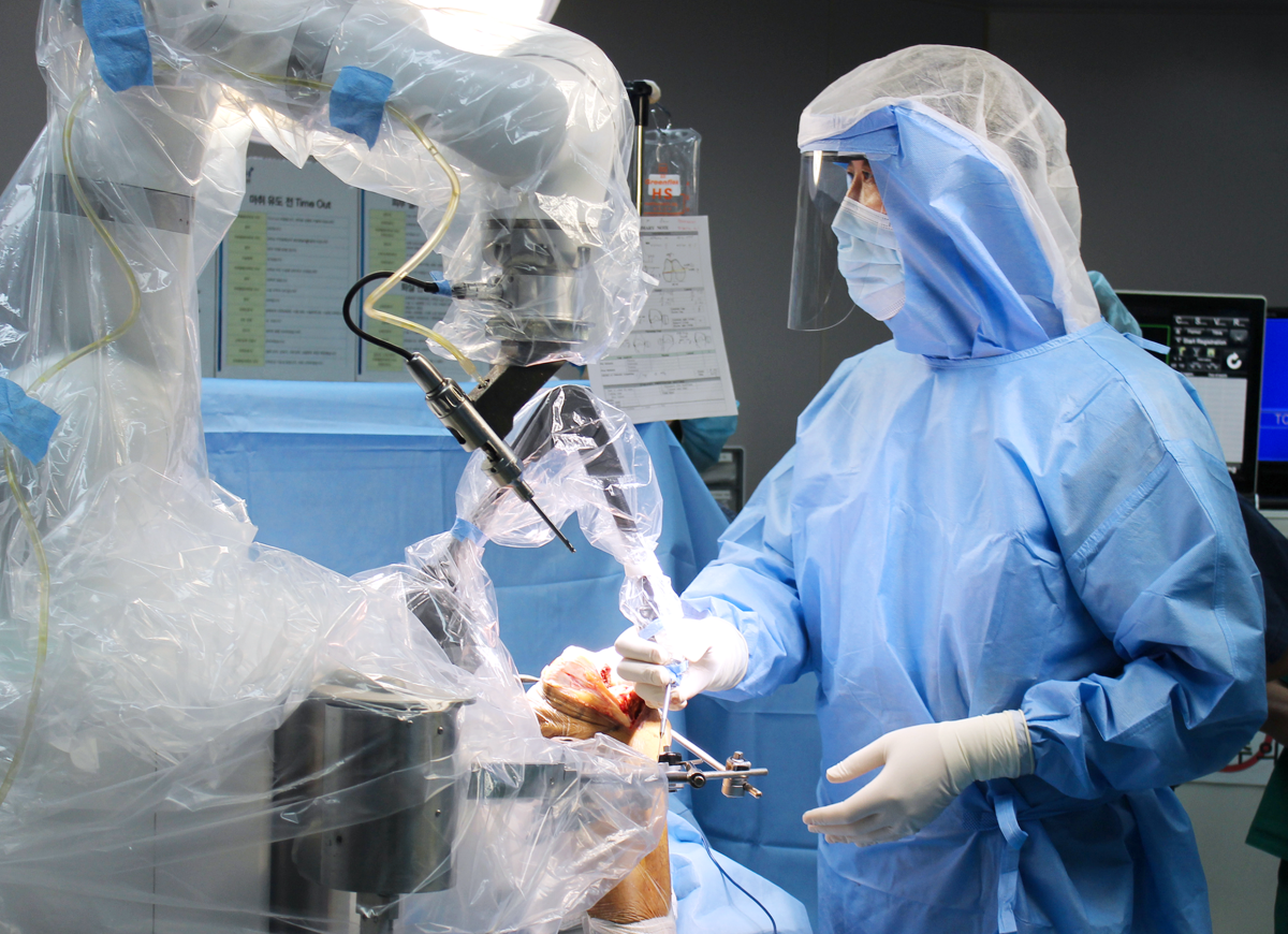 ▲이춘택병원 윤성환 병원이 수술실에서 로봇 보조 외과 절차를 수행하며, 의료진이 멸균 상태에서 로봇 장비를 통해 정밀한 무릎 인공관절 수술을 진행하고 있다. (이춘택병원)