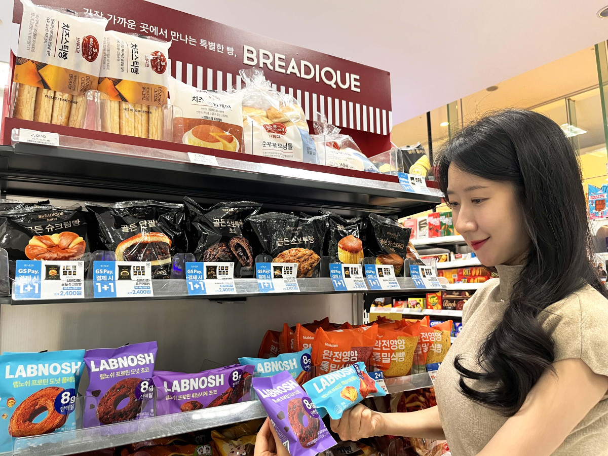 ▲모델이 랩노쉬 프로틴 휘낭시에 플레인, 랩노쉬 프로틴 도넛 초코를 바라보고 있다. (사진제공=GS리테일)