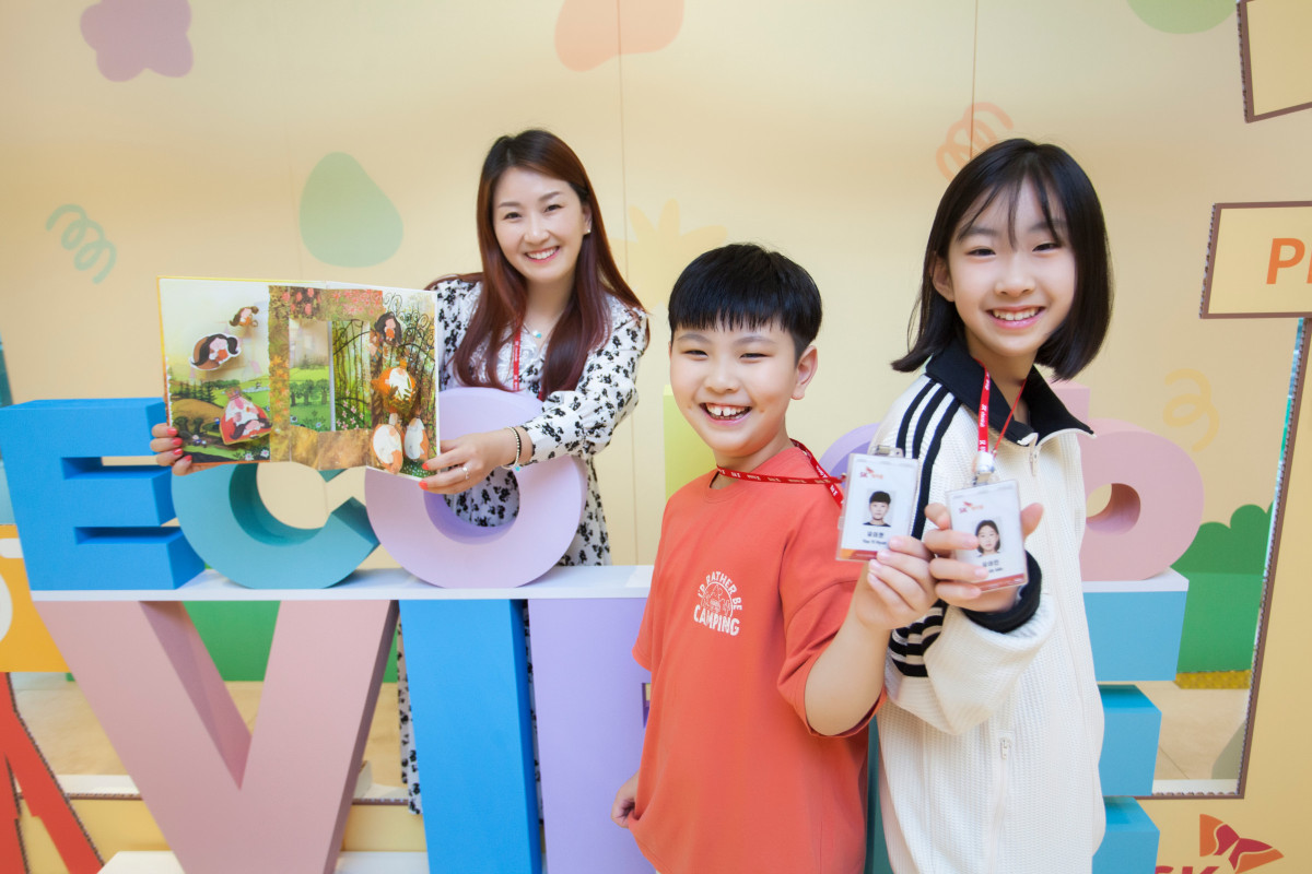 ▲SK케미칼 구성원 가족이 명예 사원증과 봉사활동에 참여해 제작한 팝업북을 들고 기념 촬영하고 있다. (사진제공=SK케미칼)