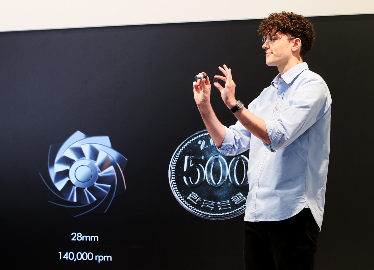▲네이슨 로슨 맥클린(Nathan Lawson McLean), 다이슨 시니어 엔지니어링 매니저가 26일 성수에서 열린 신제품 출시 행사에서 펜슬백 FluffyCones™ 청소기를 소개하고 있다. 28mm 모터와 500원 동전의 직경을 비교하는 모습. (사진제공-다이슨코리아)