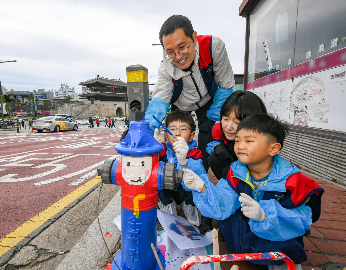▲현대모비스 임직원과 가족들이 화재 예방과 시인성 향상을 위해 지상식 소화전에 도색 봉사활동을 실시하고 있는 모습. (사진=현대모비스)