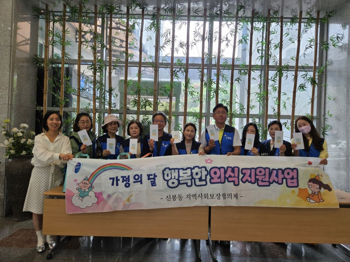 ▲신봉동 지역사회보장협의체 위원들이 23일 가정의 달을 맞아 외식비 지원사업 현수막을 들고 기념사진을 찍었다. (용인특례시)