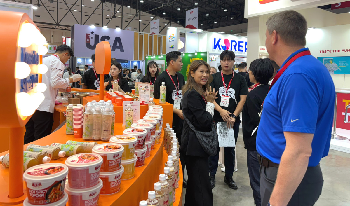 ▲‘태국 국제식품박람회’에서 동원F&B 직원이 부스를 방문한 외국인에게 제품을 소개하고 있다 (사진제공=동원F&B)