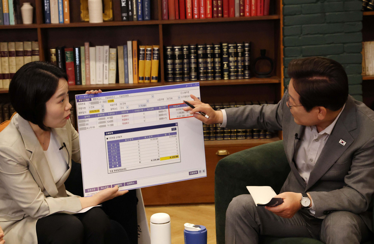 ▲이재명 더불어민주당 대선후보가 28일 서울 신사동 가로수길 미드타운 스튜디오에서 'K-이니셔TV 1400만 개미와 한배 탔어요' 유튜브 라이브에서 이소영 의원이 들고 있는 본인 투자 종목을 손으로 가리키고 있다. 신태현 기자 holjjak@