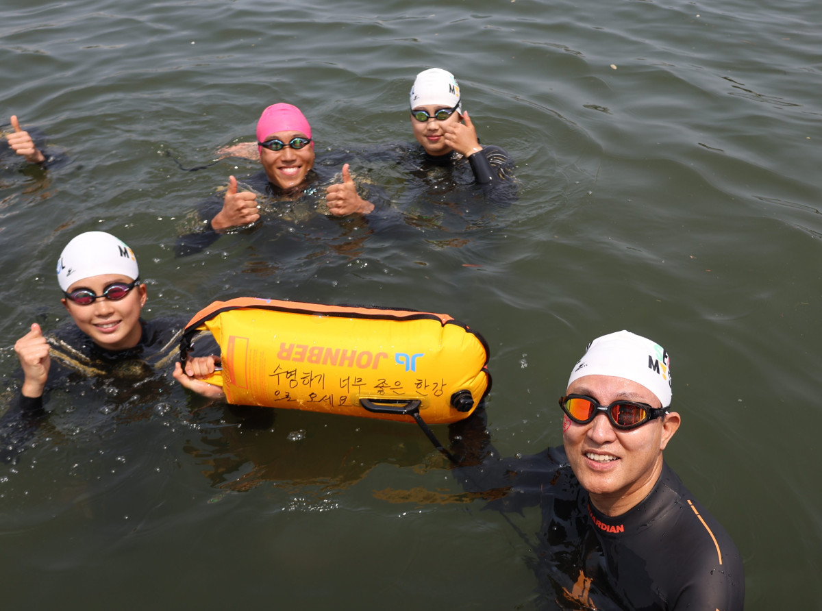 ▲ 오세훈 서울시장이 30일 ‘쉬엄쉬엄 한강 3종 축제’ 1일차 수영종목에 출발 전 ‘수영하기 너무 좋은 한강으로 오세요 수질 환상적!’ 안전부이를 들고 도강을 준비하고 있다. (사진 제공 = 서울시)
