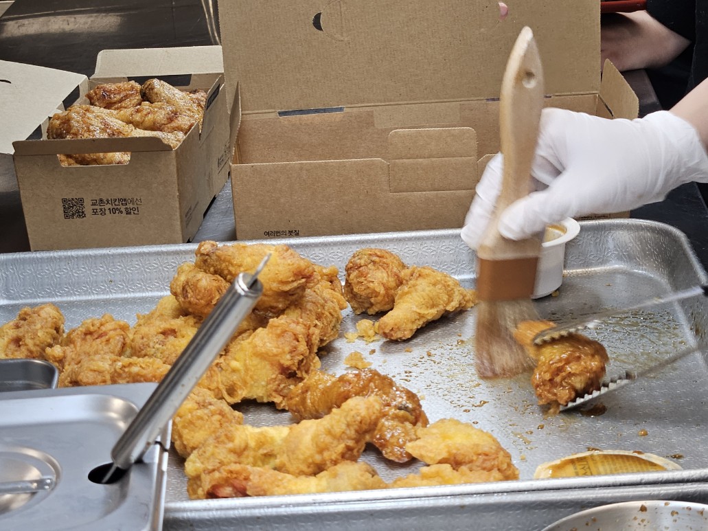 ▲교촌199스쿨 참가자가 치킨 조각에 소스를 정성껏 바르고 있다. (사진=문현호 기자 m2h@)