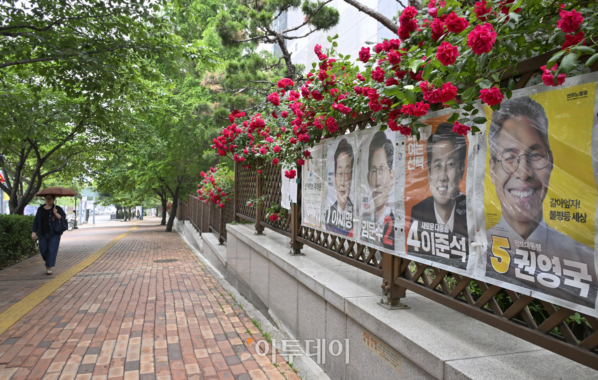 ▲제21대 대통령선거를 하루 앞둔 2일 서울 시내의 한 아파트 화단에 심어진 장미꽃 밑으로 대선 선거벽보가 게시돼 있다. 제21대 대선 본투표는 3일 오전 6시부터 오후 8시까지 전국 투표소 1만4295곳에서 치뤄진다. 한편 이날 이재명 더불어민주당 대선 후보와 김문수 국민의힘 대선 후보 모두 서울에서 마지막으로 유권자를 만난다. 이재명 후보는 여의도공원에서, 김문수 후보는 서울시청 앞 광장에서 피날레 유세를 펼칠 예정이다. 이준석 개혁신당 대선 후보는 대구 수성구 수성못 일대에서, 권영국 민주노동당 대선 후보는 종로구 보신각에서 유세를 마무리 한다. 조현호 기자 hyunho@
