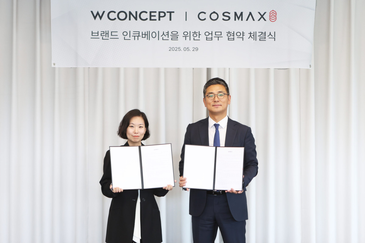 ▲안지수 W컨셉 상품기획담당(왼쪽)과 최재우 코스맥스 국내마케팅본부 부문장(오른쪽)이 업무협약 체결 후 기념사진을 촬영하고 있다. (사진제공=W컨셉)