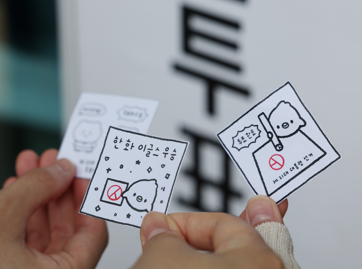 ▲제21대 대통령선거 사전투표 첫날인 29일 서울 강남구 삼성2동주민센터에 마련된 사전투표소 앞에서 시민들이 투표 도장이 찍힌 그림을 들고 기념 촬영을 하고 있다. 연합뉴스 