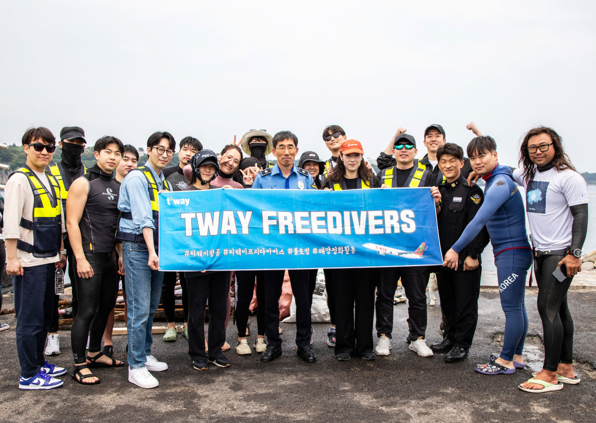 ▲지난달 31일 제주도 서귀포항 해안가에서 진행된 해양 정화 활동 후 티웨이항공 프리다이버스와 박상춘 제주지방해양경찰청장(가운데), 전장원 플로빙코리아 대표(오른쪽에서 첫 번째)가 기념 사진을 촬영하고 있다. (사진=티웨이항공)