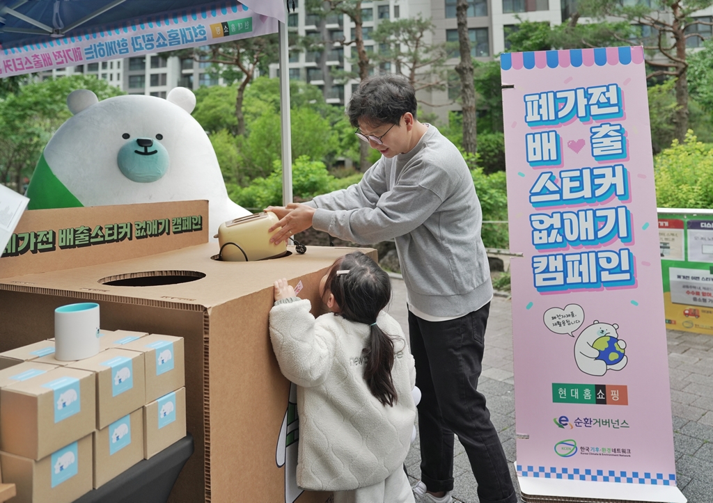 ▲서울 강동구 고라시움아파트에 설치된 현대홈쇼핑의 '전자폐기물 자원순환 캠페인' 체험 부스를 아파트 주민이 이용하고 있다. (사진제공=현대백화점그룹)