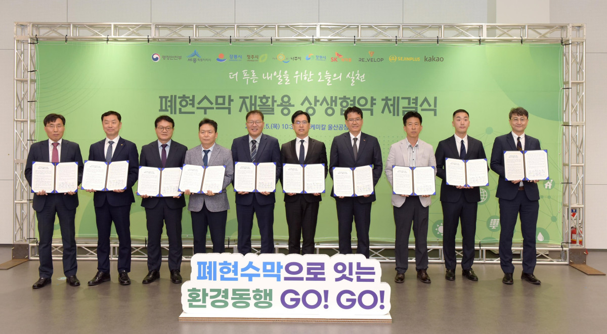▲SK케미칼이 5일 울산 남구에 위치한 SK케미칼 울산 공장에서 5개 지방자치단체, 리벨롭, 세진플러스, 카카오와 함께 ‘지역·기업 상생 발전을 위한 폐현수막 재활용 업무 협약’을 체결했다. 김현석 SK케미칼 리사이클사업본부장(오른쪽 네번째), 김민재 행정안전부 차관보(오른쪽 다섯번째) 등이 체결식을 마치고 기념사진을 촬영하고 있다. (SK케미칼)