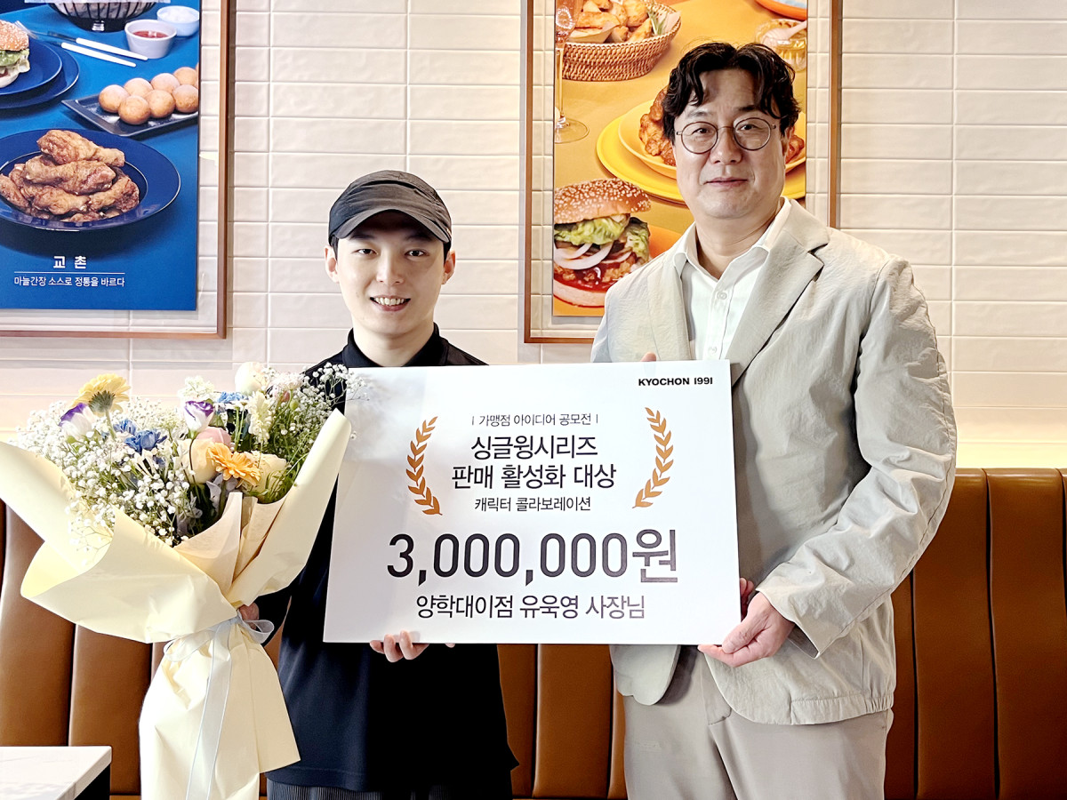 ▲유욱영 교촌치킨 양학대이점주(왼쪽)가 경북 포항 ‘교촌치킨 양학대이점’에서 진행된 싱글윙 시리즈 판매 활성화 아이디어 공모전 시상식에서 이상로 교촌에프앤비 국내사업부문장(오른쪽)으로부터 ‘싱글윙시리즈 판매 활성화 대상’을 수상하고 기념사진을 촬영하고 있다. (사진제공=교촌에프앤비)