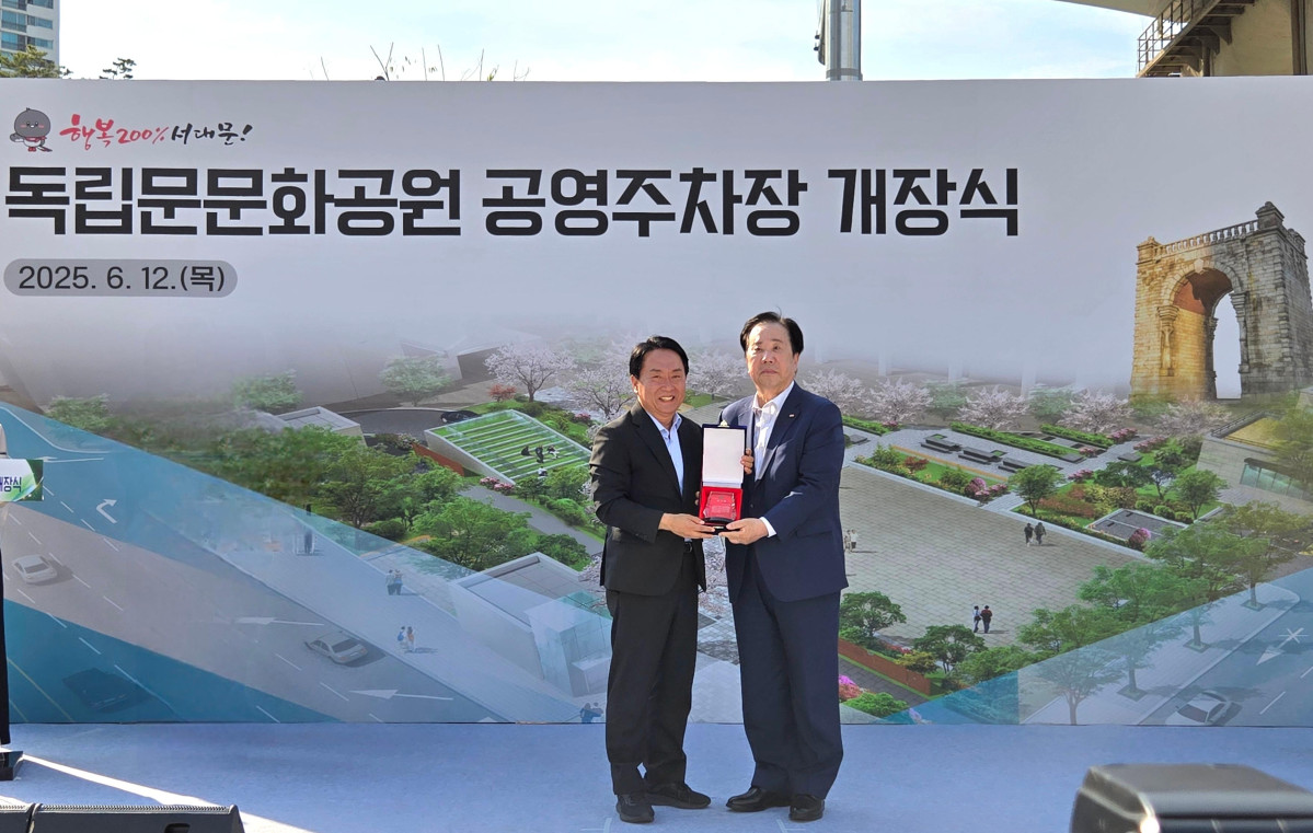 ▲우오현 SM그룹 회장(오른쪽)이 12일 오후 서울 서대문구 독립문문화공원 공영주차장 개장식에서 이성헌 서대문구청장으로부터 감사패를 받으며 기념촬영을 하고 있다. (사진=SM그룹)