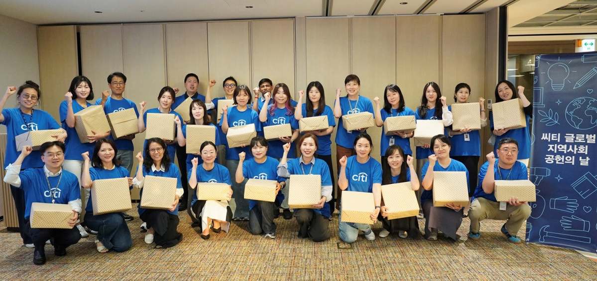 ▲씨티 글로벌 지역사회 공헌의 날 20주년을 맞아 12일 서울 종로구 씨티은행 본점에서 임직원들이 파란색 셔츠를 입고 학습물품 박스를 제작하며 단체로 기념촬영을 하고 있다. (사진제공=한국씨티은행)