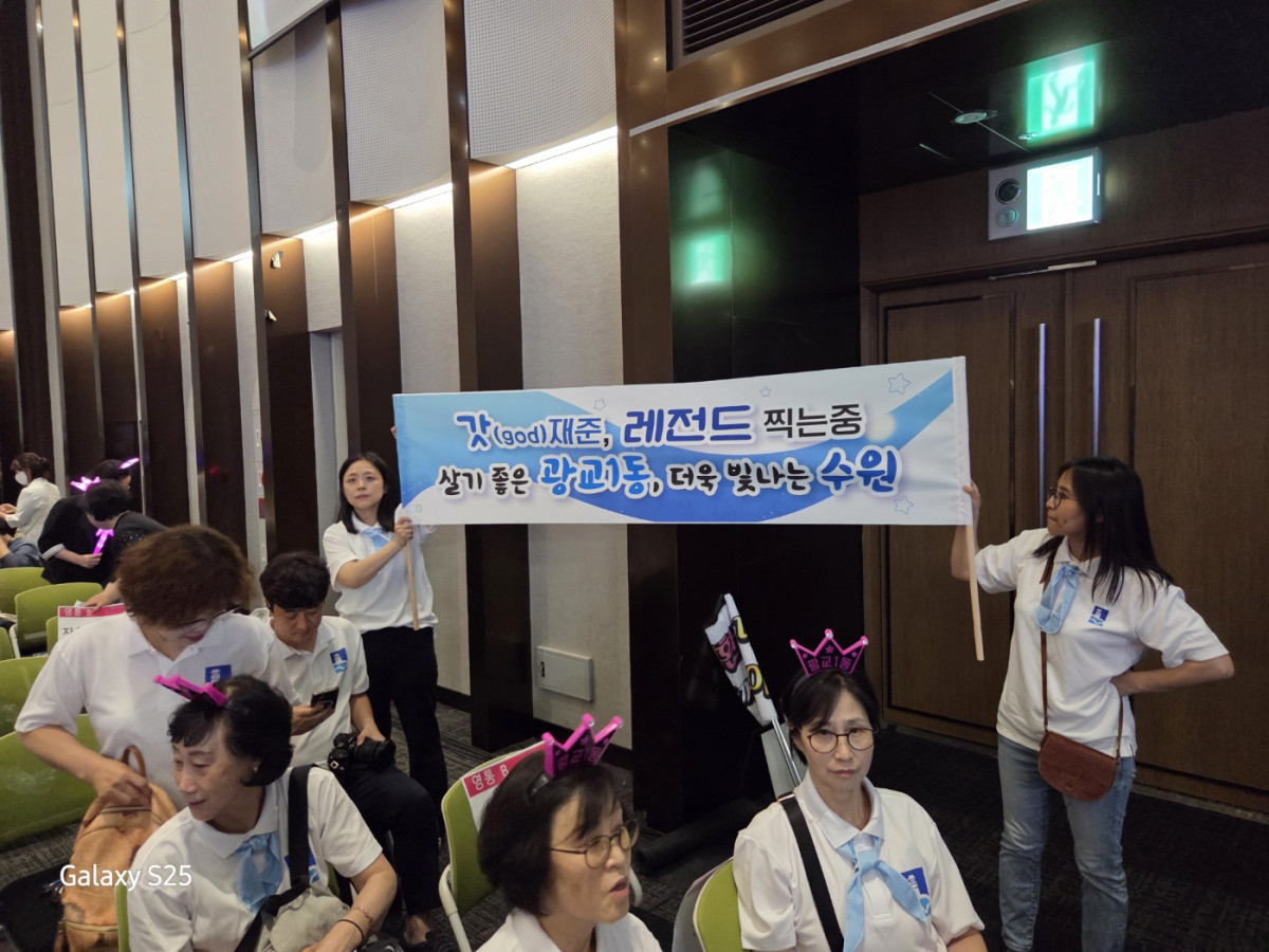 ▲수원특례시 광교1동 봉사자들이 13일 수원컨벤션센터에서 열린 ‘2025 새빛 힐링콘서트’ 행사장에서 응원현수막을 들고 힐링콘서트를 즐겼다 . (김재학 기자)
