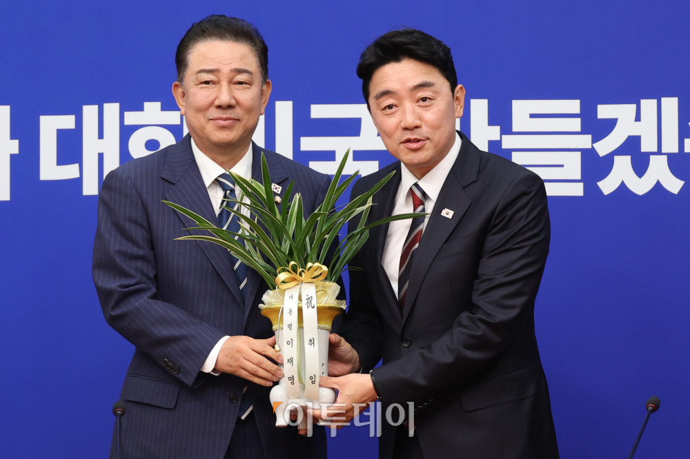 ▲강훈식(오른쪽) 대통령 비서실장이 17일 서울 여의도 국회에서 김병기 더불어민주당 대표 직무대행 겸 원내대표를 예방해 이재명 대통령의 축하난을 전달하고 기념촬영을 하고 있다. 고이란 기자 photoeran@