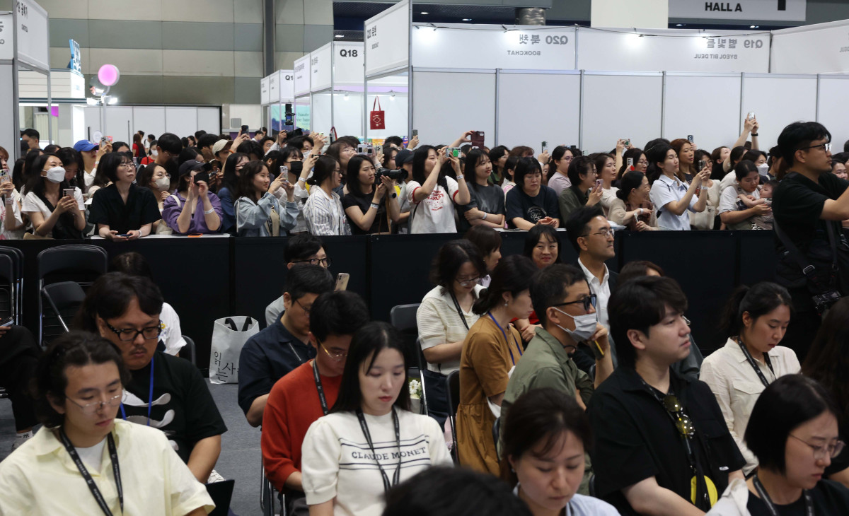 ▲18일 서울 강남구 코엑스에서 열린 ‘2025 서울국제도서전’ 한국에서 가장 좋은 책 시상식에서 참관객들이 문재인 전 대통령의 축사를 듣고 있다. 신태현 기자 holjjak@
