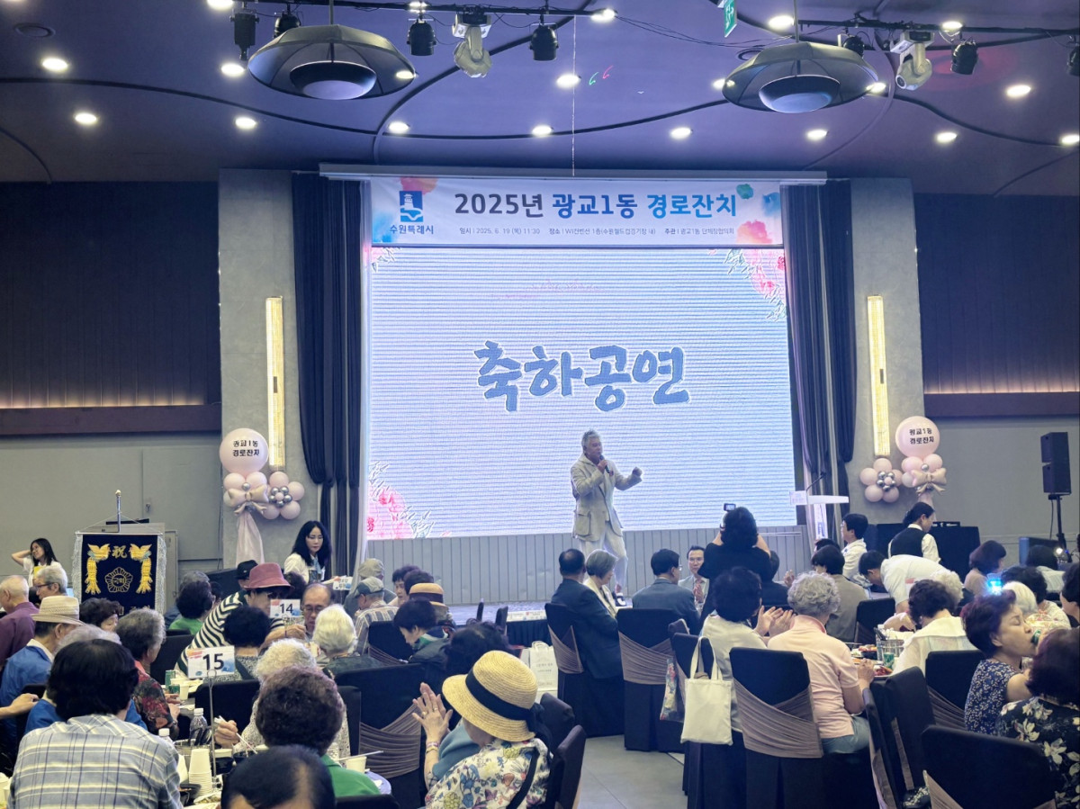 ▲광교1동 경로잔치 행사장에서 축하공연을 진행하고, 참석자들이 테이블에 앉아 관람하고 있다. (수원특례시 영통구 광교1동)