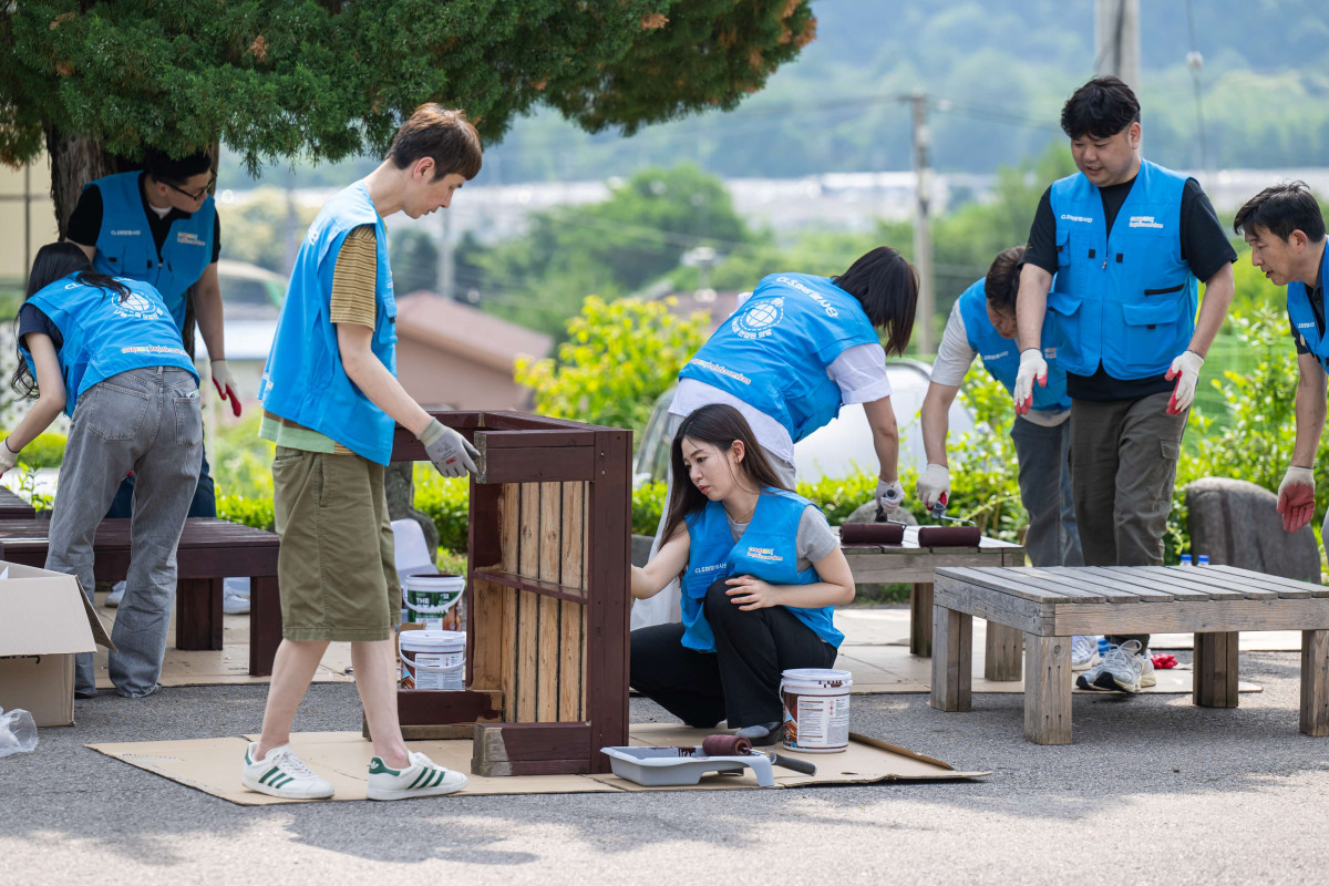 ▲19일 쿠팡로지스틱스서비스 임직원들이 경기도 포천시에 있는 아동보육시설 꿈이있는마을에서 야외평상 페인팅 작업을 하고 있다.