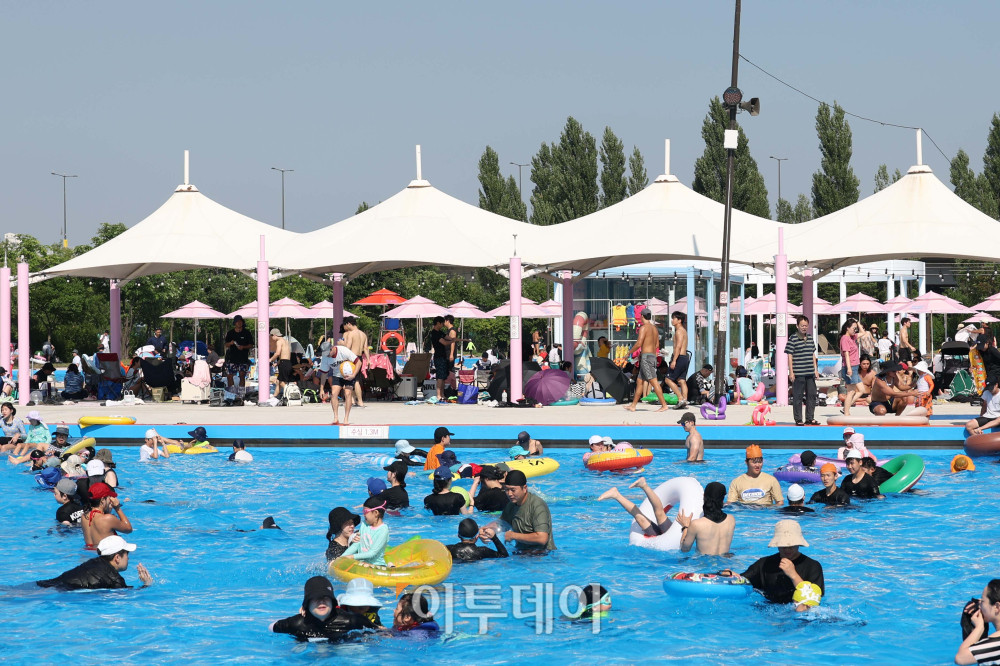 ▲전국에 내리던 장맛비가 그치고 초여름 더위가 찾아온 22일 개장 첫 주말을 맞은 서울 여의도 한강공원 수영장을 찾은 어린이와 시민들이 물놀이를 하고 있다. 고이란 기자 photoeran@
