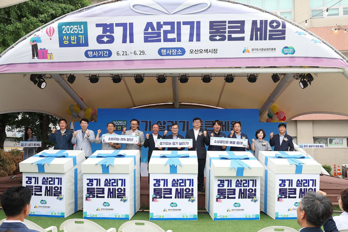 ▲김동연 경기도지사가 오산 오색시장에서 열린 2025년 상반기 경기 살리기 통큰세일 개막 행사 무대에 여러 인사들과 함께 서서, 소비 인증 및 지역경제 활성화를 알리는 팻말을 들고 있다. (경기도)