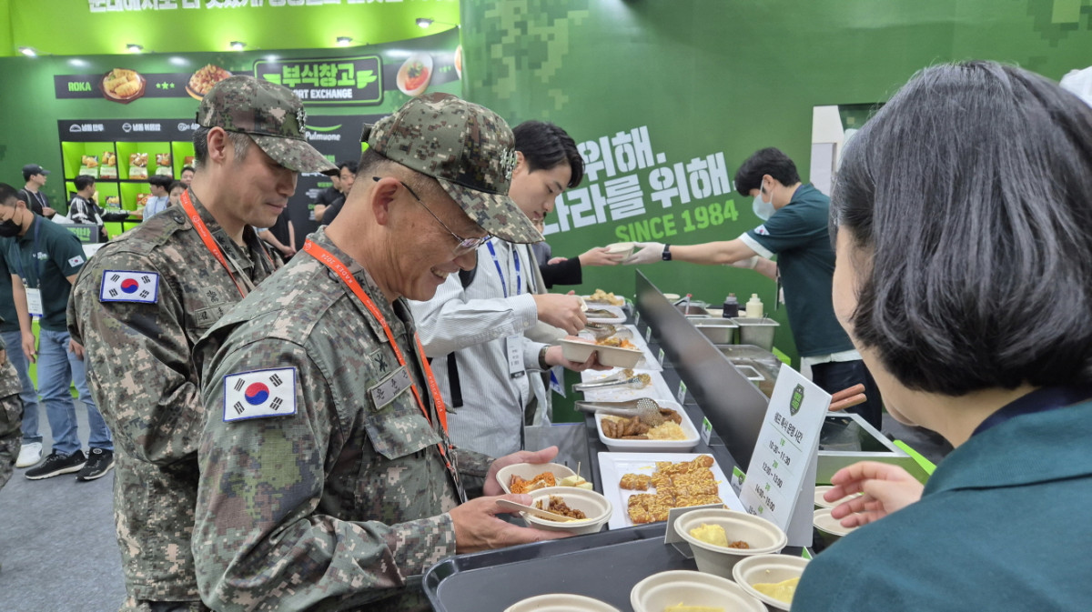 ▲대한민국 국제방위산업전시회 풀무원 미식 작전본부' 부스에 방문한 군 관계자가 시식용 음식을 받고 있다. (사진제공=풀무원)