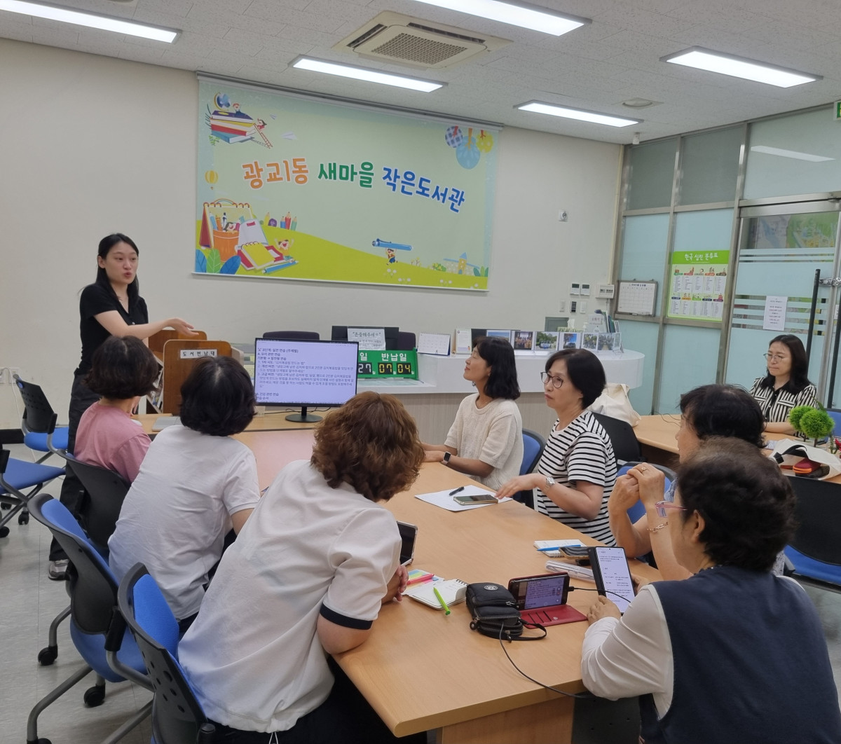 ▲광교1동 새마을 작은도서관에서 여러 주민들이 둥근 테이블에 앉아 발표자로부터 생성형 AI 교육을 받고 있다. (수원시 영통구 광교1동 )