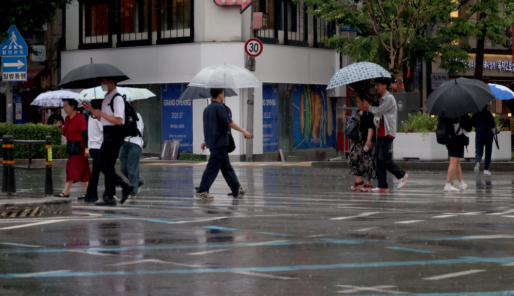 ▲ 서울 세종대로사거리에서 우산을 쓴 시민들이 발걸음을 옮기고 있다. (이투데이 DB)