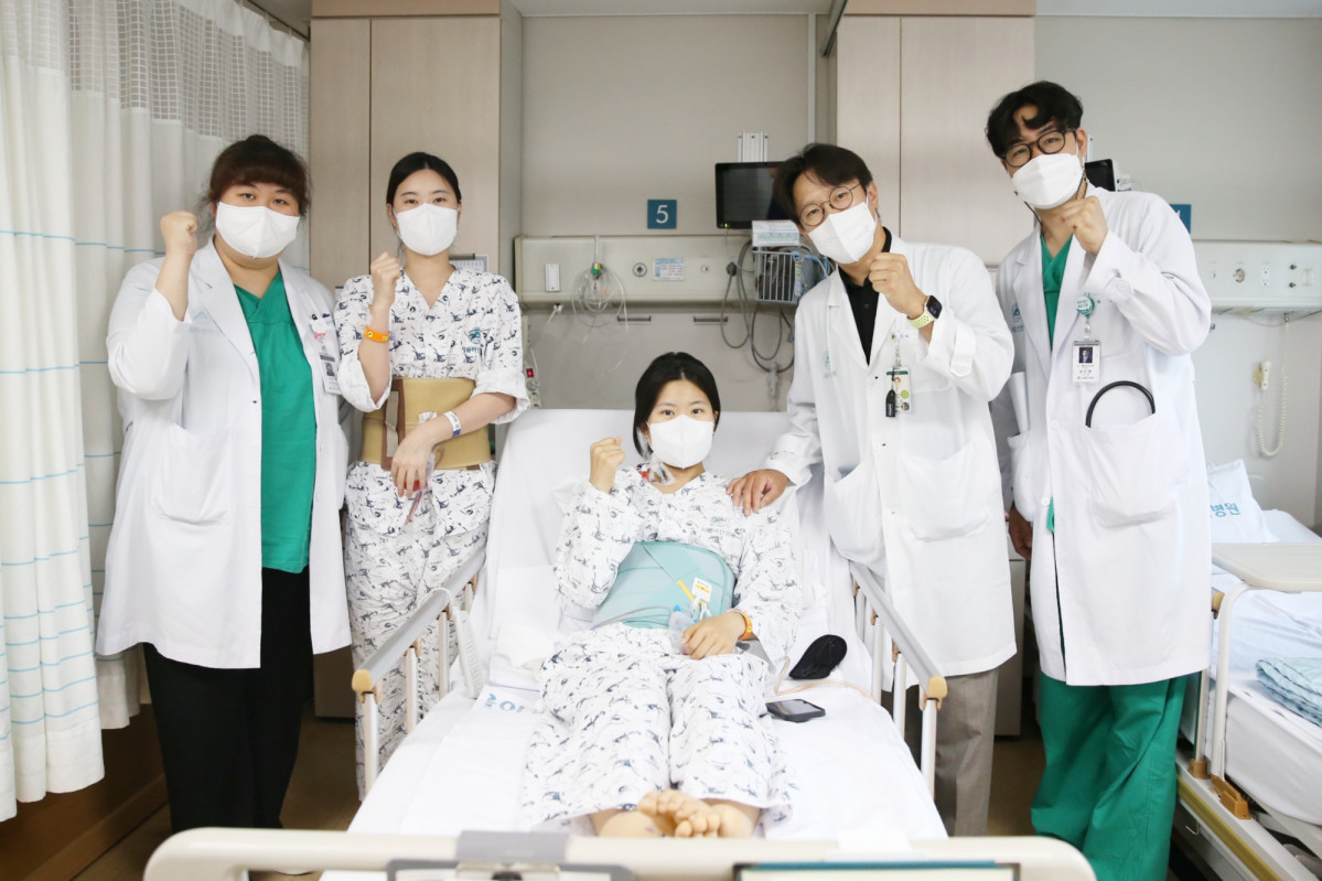 ▲다낭성 신증후군으로 만성 신부전을 앓던 이가영 씨(가운데)가 로봇 신장이식 후 순조롭게 회복하며 20일(금) 의료진과 기념사진을 찍고 있다. 공여자인 언니 이 모 씨(왼쪽에서 두 번째), 수술을 집도한 신성 서울아산병원 신·췌장이식외과 교수(오른쪽에서 두 번째). (서울아산병원)