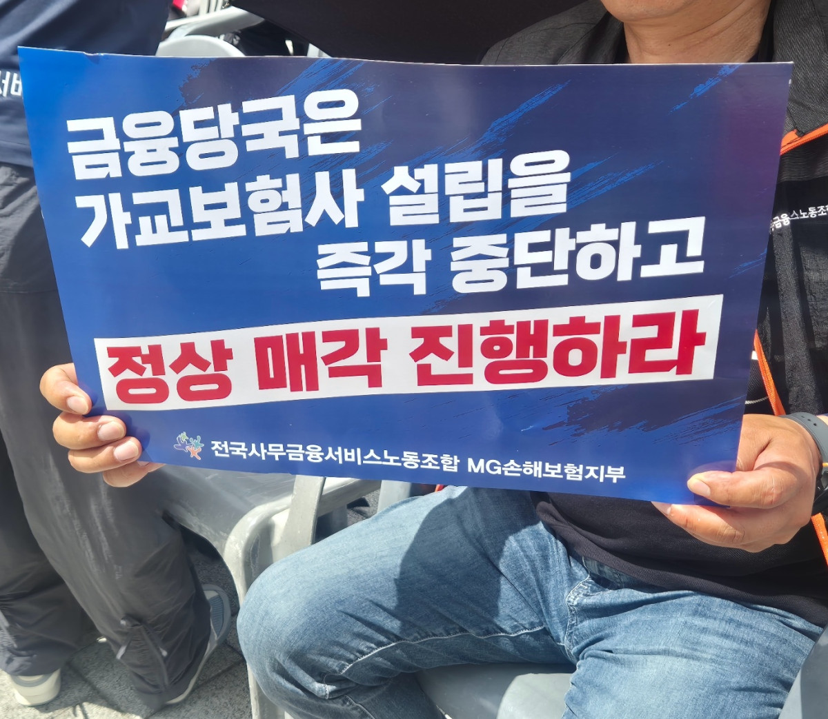 ▲30일 오전 MG손해보험 직원이  서울 용산구 대통령실 앞에서 집단 단식농성 선포 투쟁대회에 참석해 피켓을 흔들고 있다. (김재은 기자 dove@)